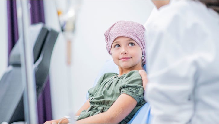 Child receiving support from a caregiver in a pediatric treatment room