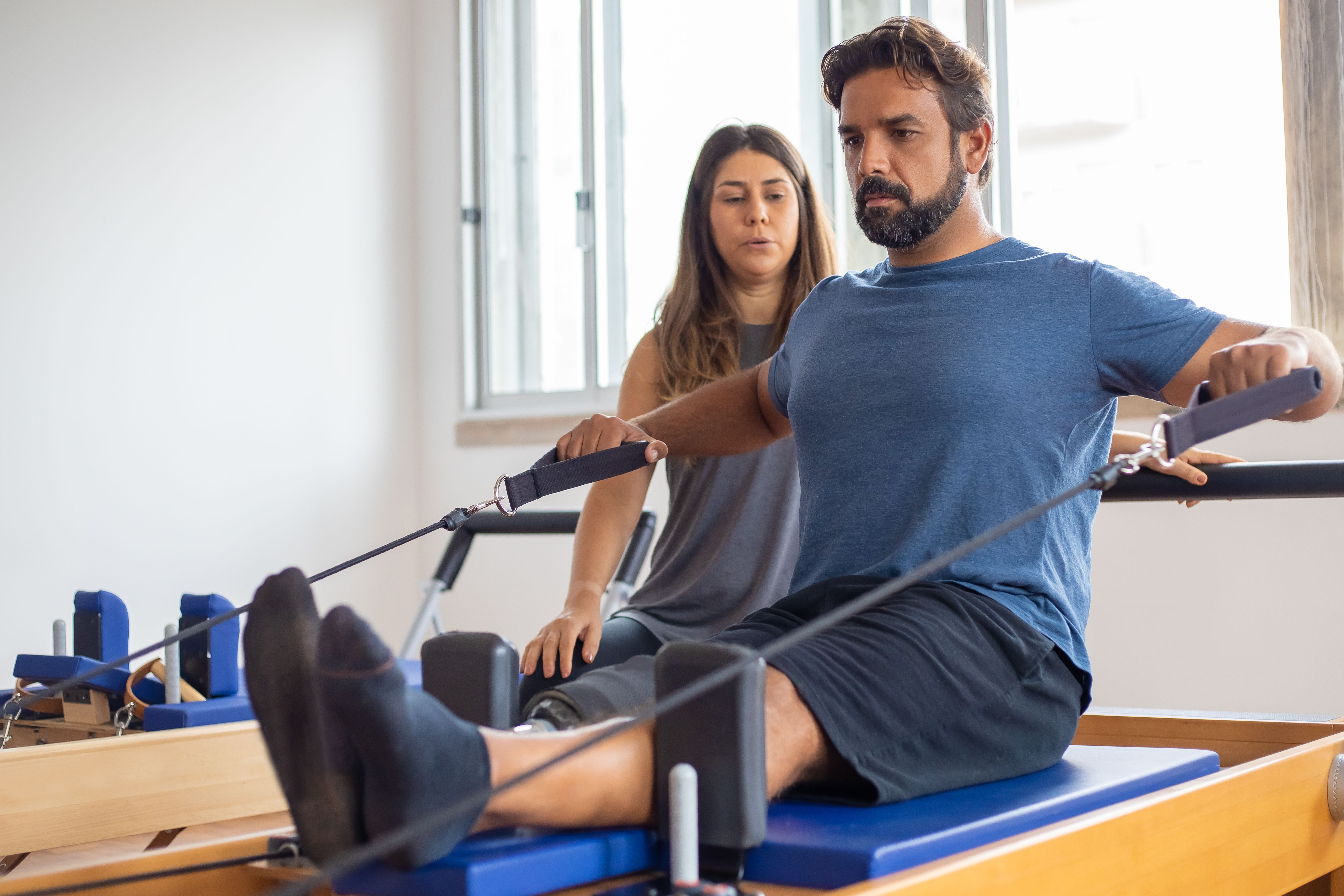 A physical therapist guiding a man through a resistance exercise